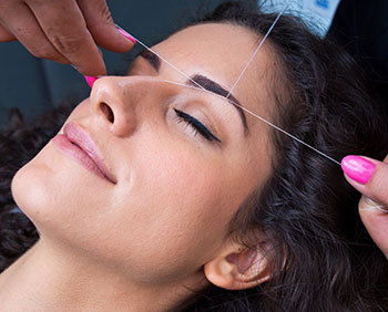 woman on facial hair removal threading procedure